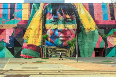 A brightly colored mural of an Indigenous Kayin woman on a wall in Rio de Janeiro, by the artist Kobra for the 2016 Olympics