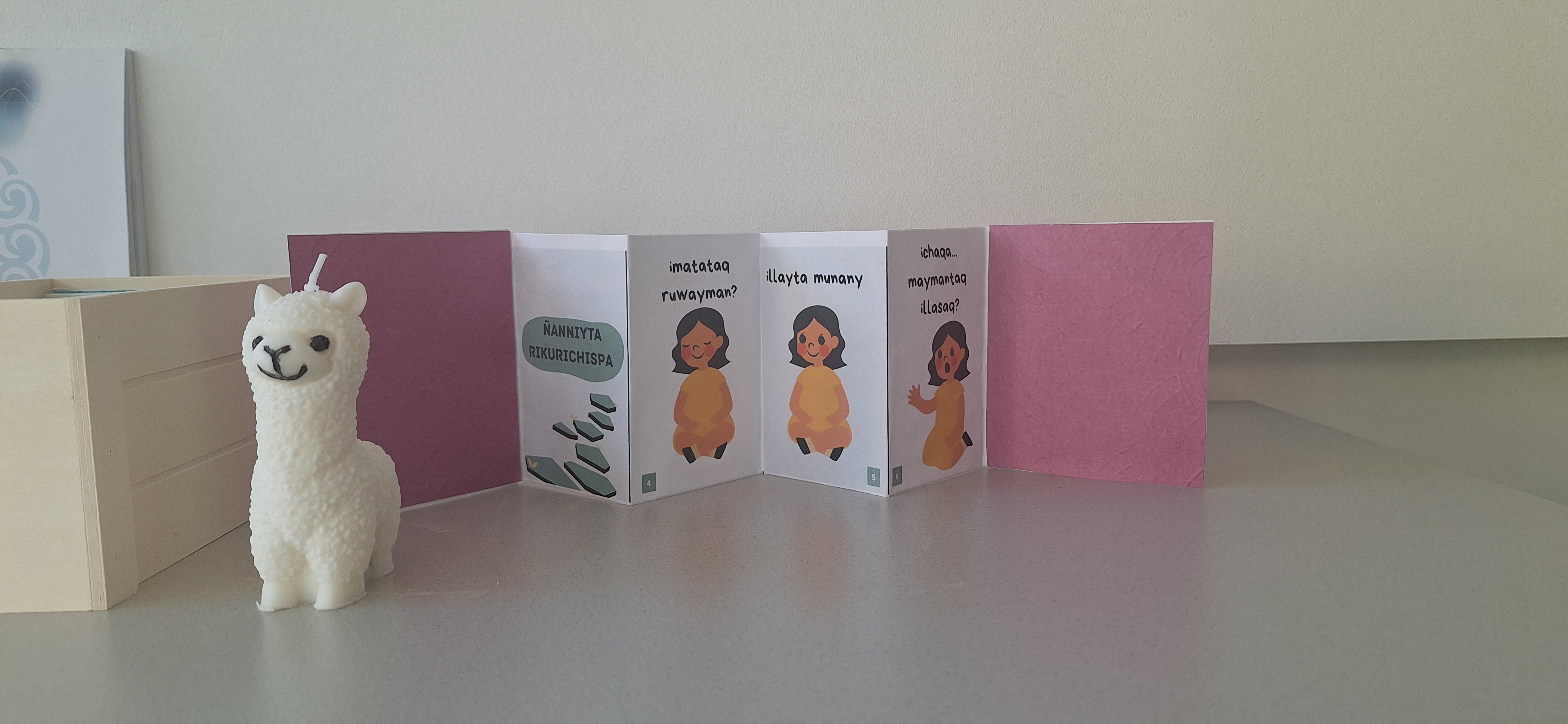 Zine printed and folded on a desk, next to a small toy alpaca.