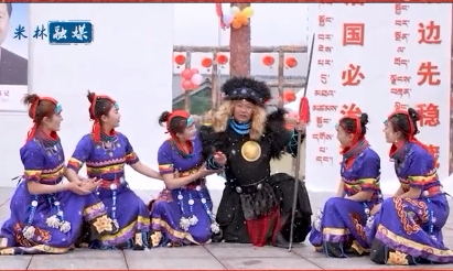 A group of Tani people in traditional dress performing on a stage
